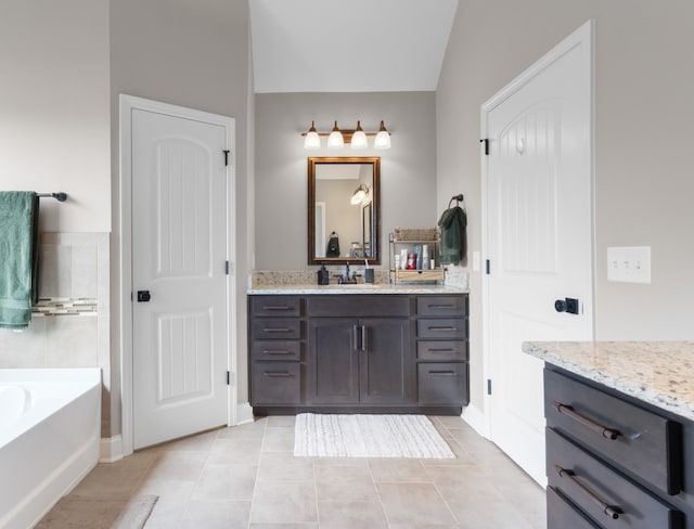 full bathroom with vanity, a bath, tile patterned floors, and vaulted ceiling