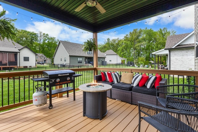 wooden deck with fence, ceiling fan, a yard, and a residential view