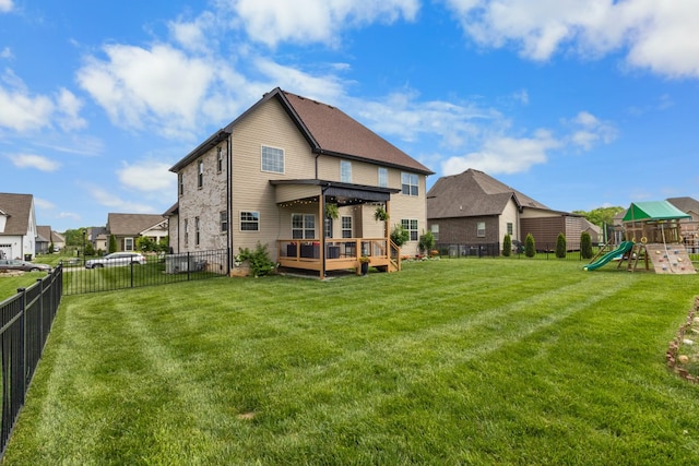 rear view of house with a residential view, a wooden deck, a fenced backyard, a playground, and a yard