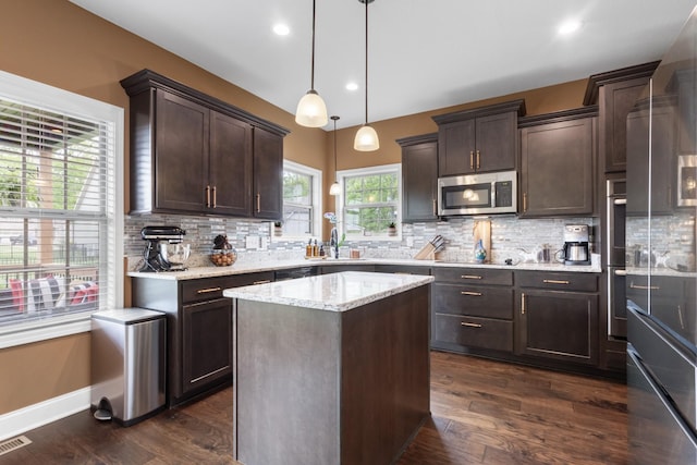 kitchen with a sink, backsplash, dark brown cabinetry, and stainless steel appliances