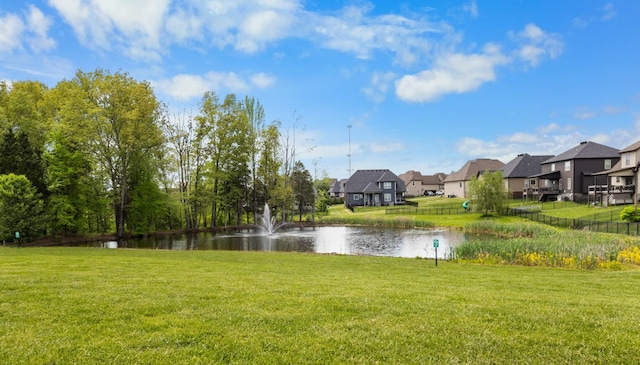 view of yard featuring a residential view, fence, and a water view