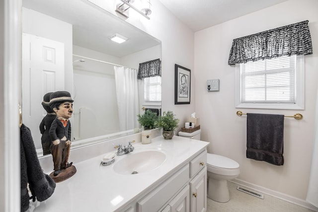 bathroom with toilet, visible vents, plenty of natural light, and vanity