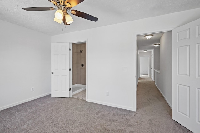 unfurnished bedroom featuring carpet flooring, a ceiling fan, baseboards, a textured ceiling, and ensuite bathroom