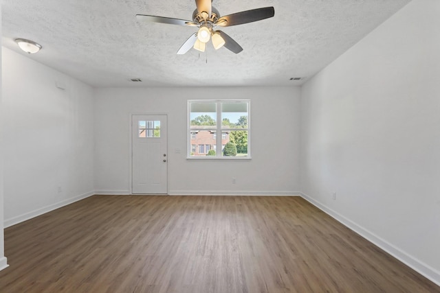 interior space with baseboards, visible vents, wood finished floors, and a textured ceiling