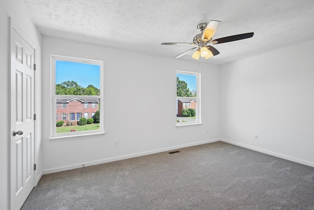 empty room with a textured ceiling, visible vents, baseboards, and carpet floors