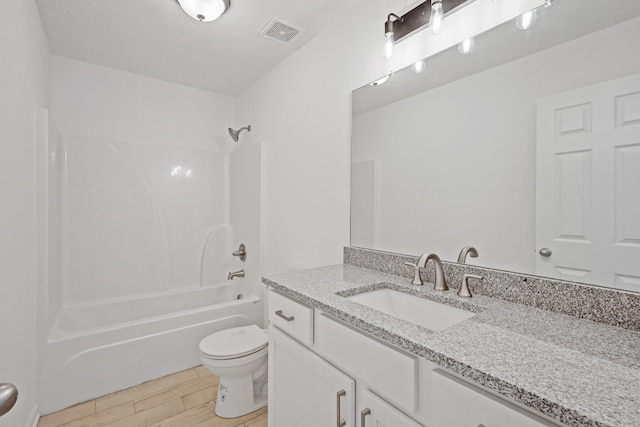 full bathroom featuring vanity, toilet, visible vents, bathtub / shower combination, and wood finished floors