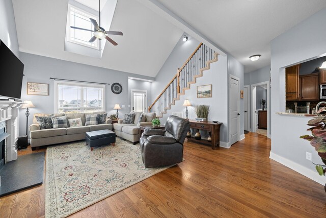 1341 Judge Tyler Dr, Clarksville, TN 37043 - living area featuring a fireplace, ceiling fan, stairs, a skylight, and wood finished floors
