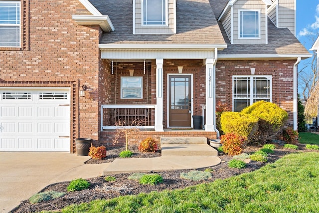 1341 Judge Tyler Dr, Clarksville, TN 37043 - view of exterior entry featuring driveway, a porch, a shingled roof, and brick siding