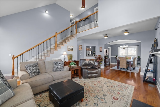 1341 Judge Tyler Dr, Clarksville, TN 37043 - living room with a chandelier, arched walkways, wood finished floors, high vaulted ceiling, and stairs