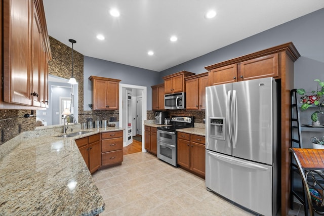 1341 Judge Tyler Dr, Clarksville, TN 37043 - kitchen with light stone counters, tasteful backsplash, brown cabinets, a sink, and appliances with stainless steel finishes