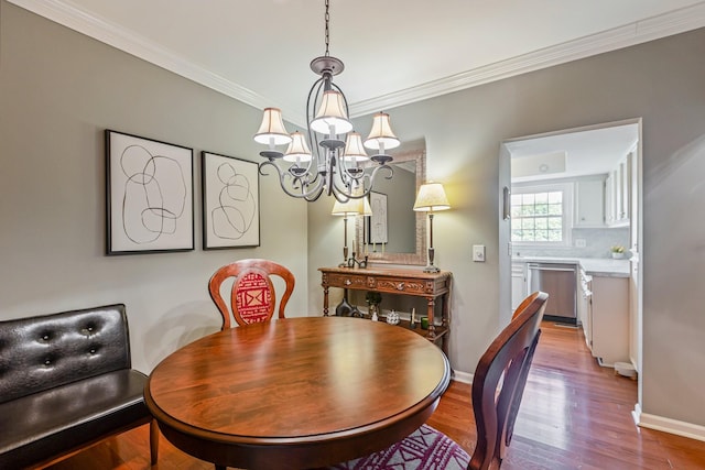dining room featuring crown molding, a notable chandelier, wood finished floors, and baseboards