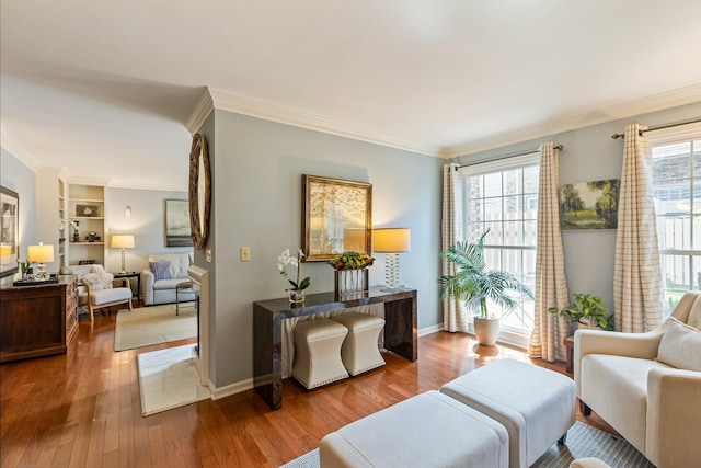 living area with baseboards, ornamental molding, and wood finished floors