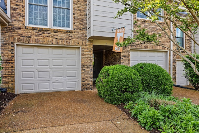 view of front facade featuring a garage, brick siding, and driveway