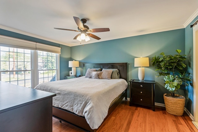 bedroom featuring baseboards, wood finished floors, ceiling fan, and crown molding