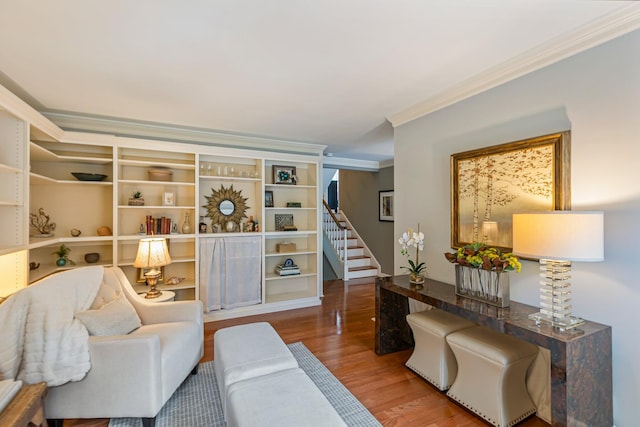 living area featuring stairway, wood finished floors, and ornamental molding