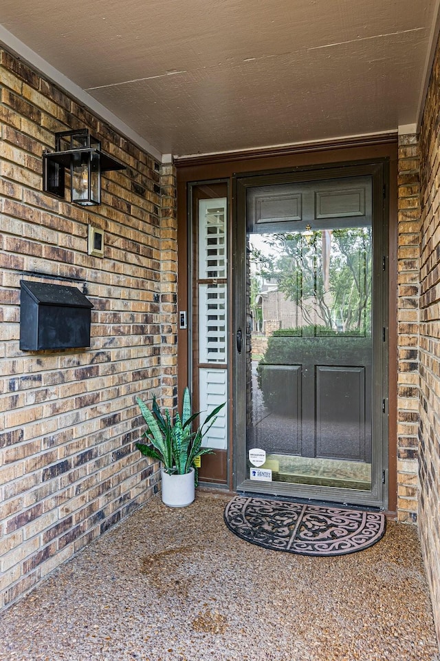 entrance to property featuring brick siding