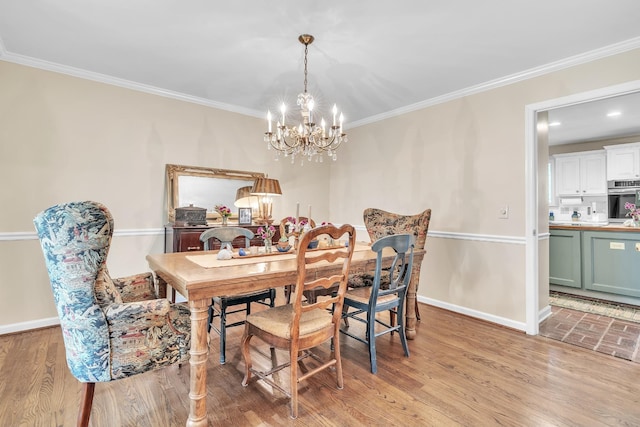 dining room with baseboards, light wood-style flooring, a notable chandelier, and crown molding