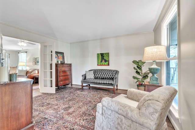 living area featuring ornamental molding, a ceiling fan, and french doors