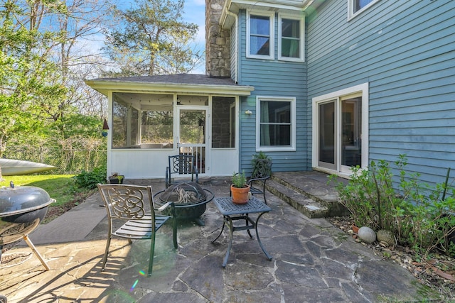 view of patio featuring a sunroom, area for grilling, and an outdoor fire pit