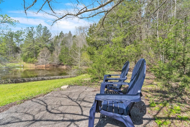 view of patio with a forest view and a water view