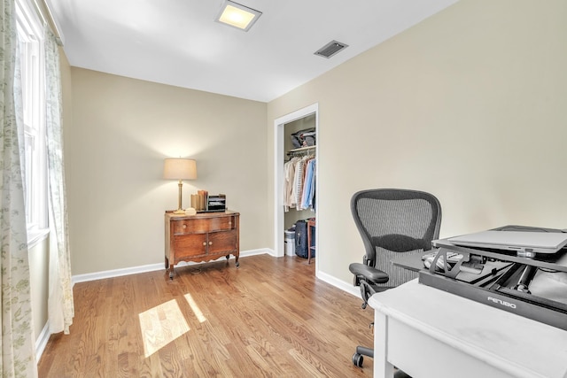 office area with baseboards, visible vents, and light wood-style flooring