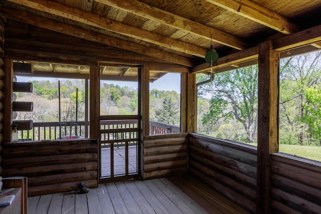 sunroom / solarium featuring beamed ceiling