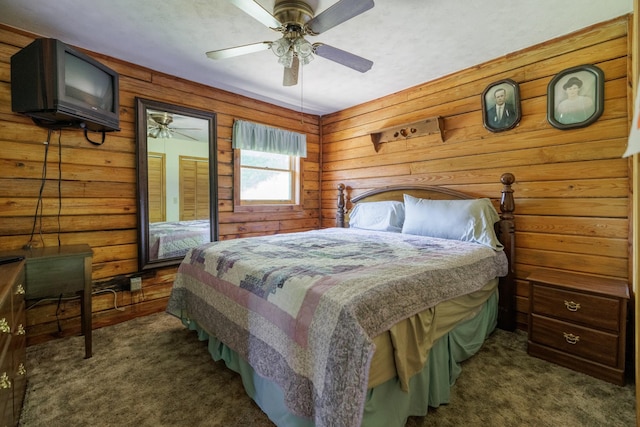 bedroom with wooden walls, ceiling fan, and dark carpet