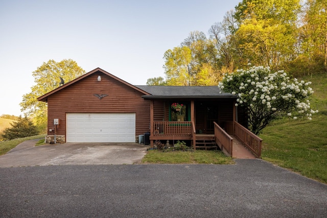 view of front of home featuring log veneer siding, covered porch, aphalt driveway, a shingled roof, and an attached garage