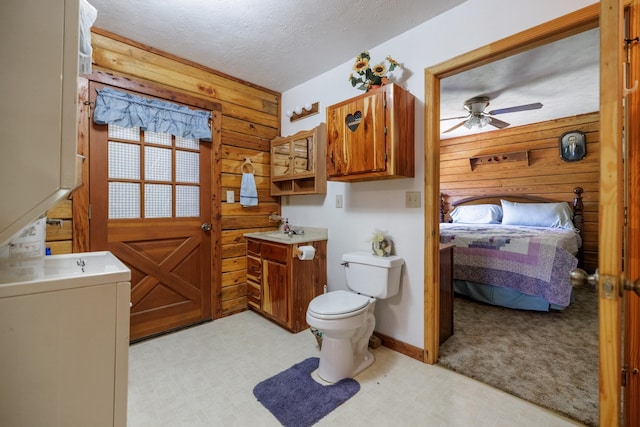 bathroom with vanity, ceiling fan, toilet, a textured ceiling, and ensuite bathroom
