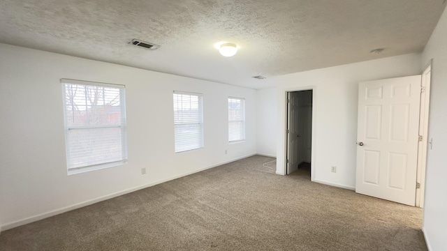 unfurnished bedroom with carpet floors, visible vents, baseboards, and multiple windows