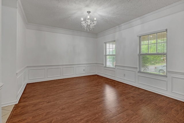 7347 Autumn Crossing Way, Brentwood, TN 37027 - empty room featuring a textured ceiling, crown molding, a chandelier, a wainscoted wall, and wood finished floors
