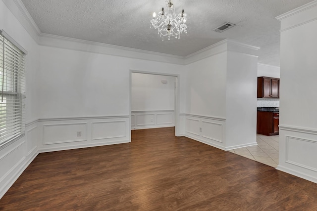 7347 Autumn Crossing Way, Brentwood, TN 37027 - empty room with a chandelier, a textured ceiling, ornamental molding, wood finished floors, and a wainscoted wall