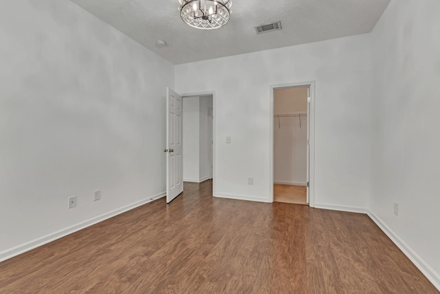 7347 Autumn Crossing Way, Brentwood, TN 37027 - unfurnished bedroom featuring a chandelier, wood finished floors, a spacious closet, and baseboards