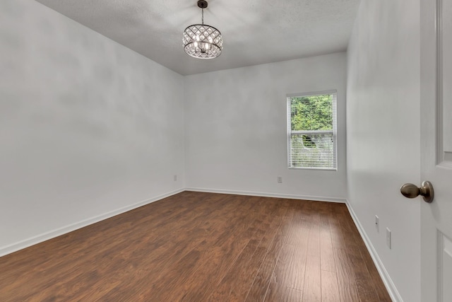7347 Autumn Crossing Way, Brentwood, TN 37027 - unfurnished room featuring dark wood-style floors, a chandelier, baseboards, and a textured ceiling