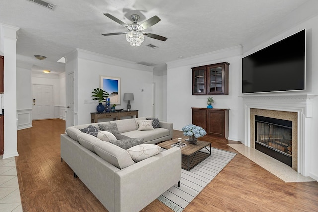 7347 Autumn Crossing Way, Brentwood, TN 37027 - living room featuring a ceiling fan, wood finished floors, a fireplace with flush hearth, ornamental molding, and a textured ceiling