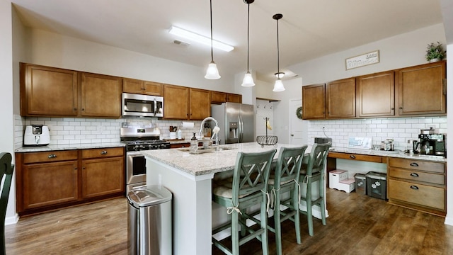 524 Burchell Ln, Columbia, TN 38401 - kitchen with decorative backsplash, appliances with stainless steel finishes, brown cabinets, a sink, and dark wood-type flooring