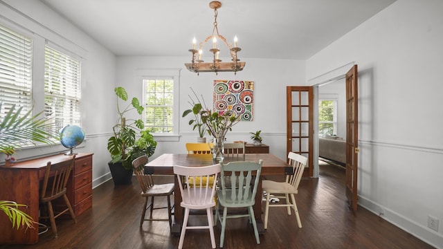 dining area featuring baseboards, wood finished floors, and a notable chandelier
