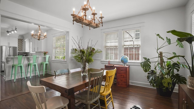 dining room with baseboards, wood finished floors, and an inviting chandelier