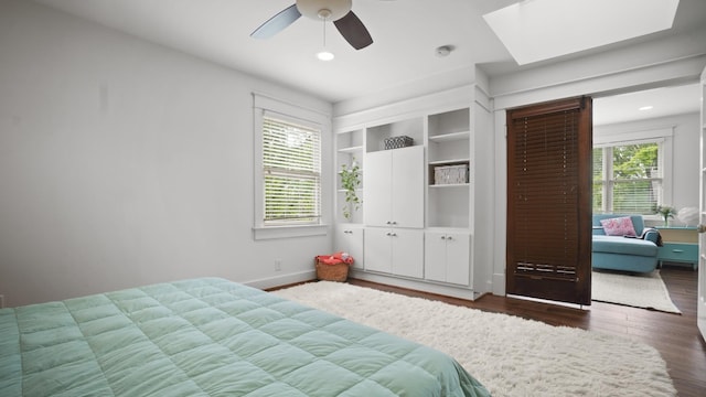 bedroom featuring recessed lighting, ceiling fan, baseboards, a skylight, and wood finished floors