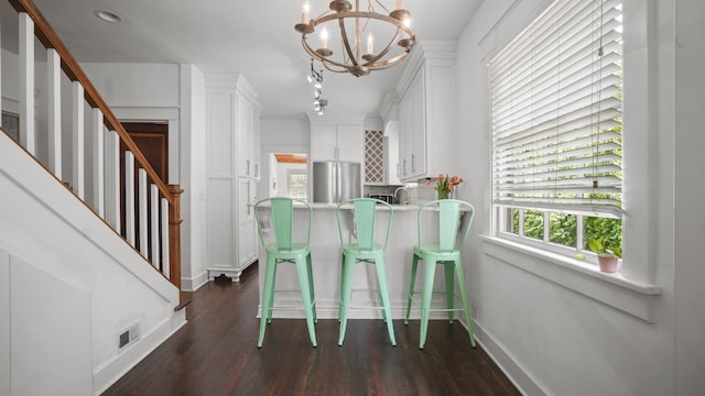 dining room with stairs, a notable chandelier, dark wood finished floors, and baseboards