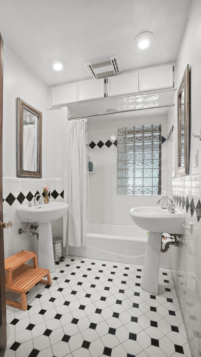 bathroom with tile walls, visible vents, a wainscoted wall, and shower / tub combo with curtain