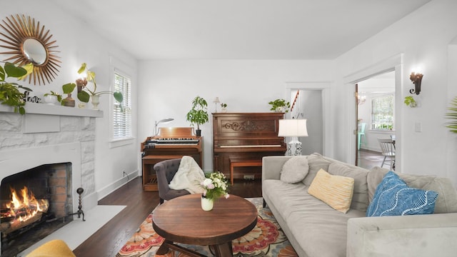 living room featuring a fireplace with flush hearth, wood finished floors, and baseboards