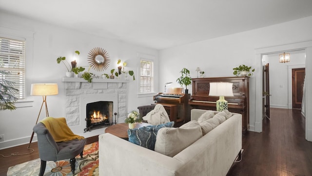 living room featuring a fireplace, dark wood-style floors, and baseboards