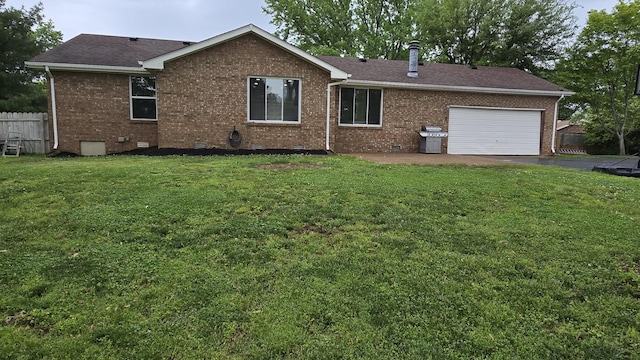 back of house featuring crawl space, brick siding, a yard, aphalt driveway, and fence