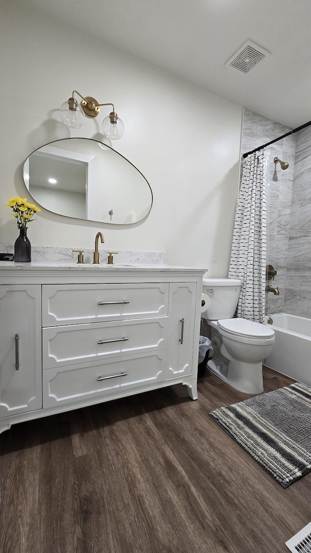 bathroom with vanity, shower / bath combination with curtain, toilet, visible vents, and wood finished floors