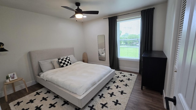 bedroom with ceiling fan, wood finished floors, and baseboards