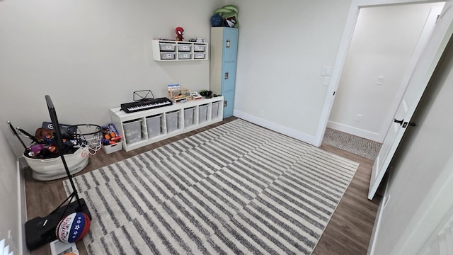 recreation room featuring wood finished floors and baseboards