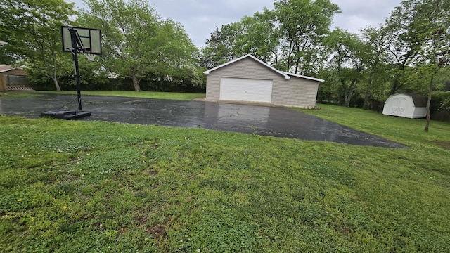 view of yard featuring an outbuilding, a detached garage, and a storage unit