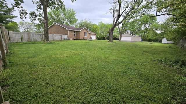view of yard with fence and an outbuilding