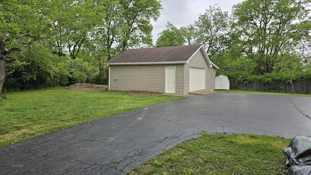 detached garage with a storage shed and aphalt driveway